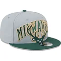 graue-und-grune-snapback-kappe-9fifty-tip-off-2023-der-milwaukee-bucks-nba-von-new-era
